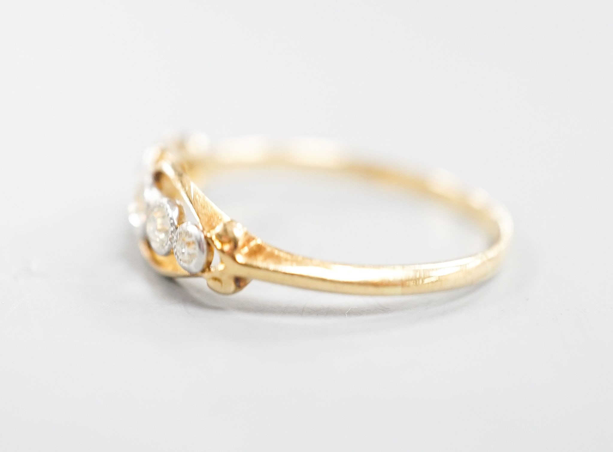 An 18ct and graduated five stone millegrain set diamond ring, size U/W, gross 2.6.